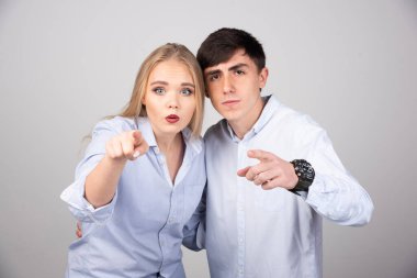 Gri arka planda ön tarafı gösteren genç bir çiftin portresi. Yüksek kalite fotoğraf