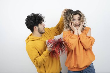 Dalgalı saçlı kadın maskeli esmer adamın yanında duruyor. Yüksek kalite fotoğraf