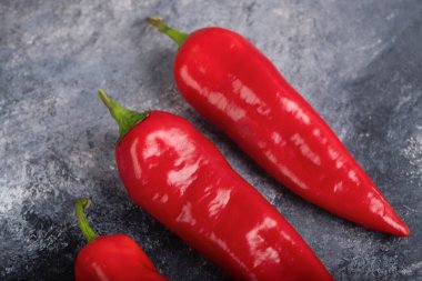 Red fresh chili peppers placed on marble surface. High quality photo
