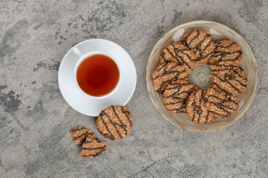 Susamlı kurabiyeler ve mermer yüzeyde bir fincan çay. Yüksek kalite fotoğraf