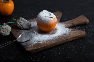 Siyah yüzeyde taze hurma ağaçları etrafında şeker tozu ile kurutulmuş hurma. Yüksek kalite fotoğraf