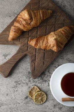 Taze ve lezzetli kruvasanlar ve bir fincan sıcak çay. Yüksek kalite fotoğraf