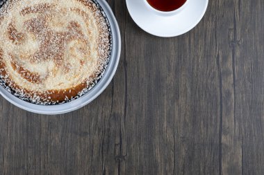 Tahta masaya bir fincan siyah çay ile bir tabak lezzetli turta. Yüksek kalite fotoğraf