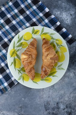 Taze ve lezzetli kruvasanlar taş masaya konmuş. Yüksek kalite fotoğraf