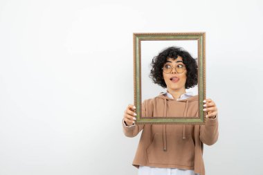 Beyaz arka planda resim çerçeveli genç bir kadının portresi 