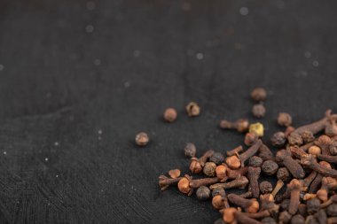 Kurumuş doğal karanfil yığını siyah yüzeye yerleştirilmiş. Yüksek kalite fotoğraf