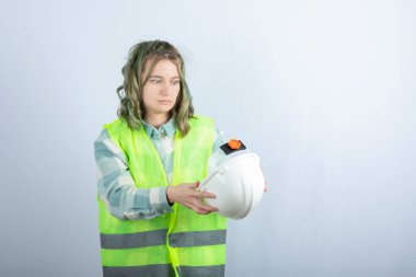 Beyaz arka planda yeşil yelek giyen genç işçinin fotoğrafı. Yüksek kalite fotoğraf