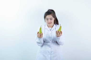 Doktor üniformalı genç kız elinde armut meyvesi tutuyor. Yüksek kalite fotoğraf