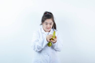 Doktor üniformalı genç kız elinde armut meyvesi tutuyor. Yüksek kalite fotoğraf
