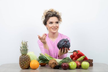 Masada elinde mor lahanayla oturan güzel bir ev hanımı resmi. Yüksek kalite fotoğraf