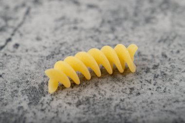 Taş yüzeyine tek pişmemiş fusilli makarna. Yüksek kalite fotoğraf