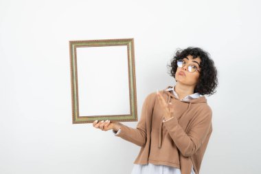 Beyaz arka planda resim çerçeveli genç bir kadının portresi 