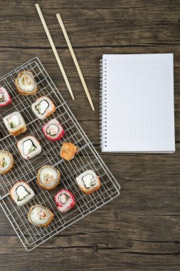 Ahşap zemin üzerinde çubuklar olan çeşitli suşi ruloları. Yüksek kalite fotoğraf