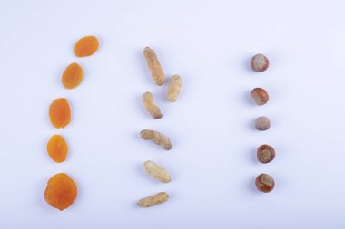 Beyaz bir masaya konmuş kurutulmuş kayısı ve kabuklu sağlıklı fıstıklar. Yüksek kalite fotoğraf