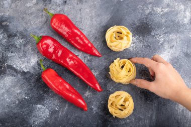 Dişi el mermer yüzeyde makarna yuvasını tutuyor. Yüksek kalite fotoğraf