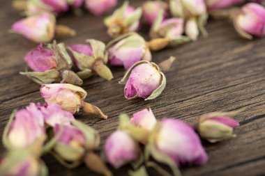 Ahşap zemine saçılmış kurumuş tomurcuk gülleri yığını. Yüksek kalite fotoğraf