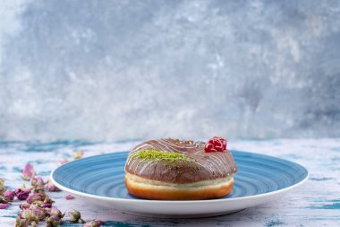 Mavi tabak lezzetli çikolata taze çörek ve kirazlı ve renkli serpiştirilmiş. Yüksek kalite fotoğraf