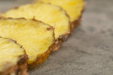 Taş zemine yerleştirilmiş lezzetli ananaslı dilimler. Yüksek kalite fotoğraf