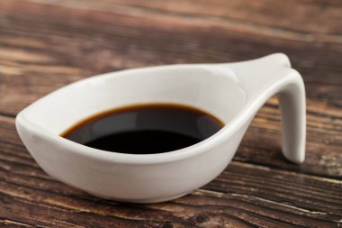 Ahşap masaya konmuş lezzetli soya soslu bir kase. Yüksek kalite fotoğraf