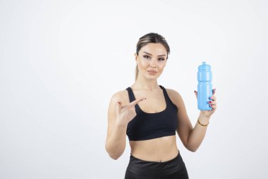 Mavi su şişesi tutan genç atletik kadın portresi. Yüksek kalite fotoğraf