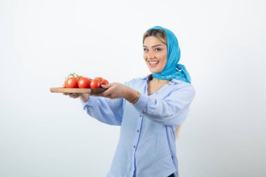 Elinde ahşap domates tahtası olan mendilli güzel bir kadın resmi. Yüksek kalite fotoğraf