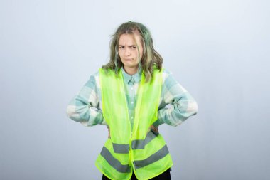 Beyaz duvarın üzerinde duran ve poz veren üniformalı kadın mimarın portresi. Yüksek kalite fotoğraf