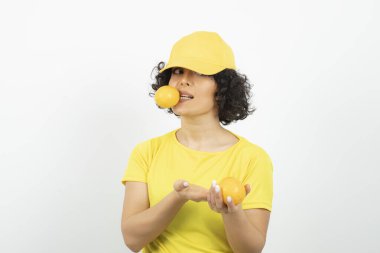 Portakallı güzel bir kadının portresi beyaz arka planda poz veriyor.  