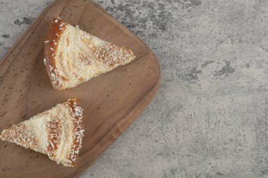 Tahtaya hindistan cevizi serpiştirilmiş iki dilim pasta. Yüksek kalite fotoğraf