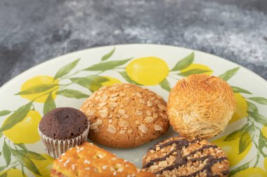 Taş zemine yerleştirilmiş tabakta tatlı atıştırmalıklar. Yüksek kalite fotoğraf