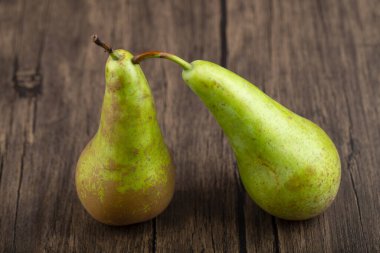 Ahşap zemin üzerinde iki olgun, lezzetli yeşil armut. Yüksek kalite fotoğraf