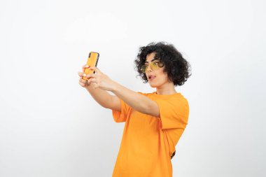 Akıllı telefonlu genç kadın beyaz arka planda poz veriyor 