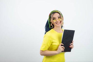 Mendilin içinde elinde bir pano olan hoş bir kadının fotoğrafı. Yüksek kalite fotoğraf