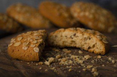 Tahta kesme tahtasına yerleştirilmiş tahıllı ve tohumlu kırık yulaf ezmeli kurabiye. Yüksek kalite fotoğraf