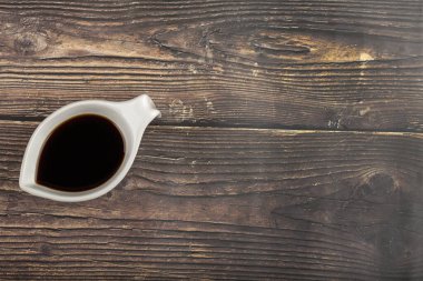 Ahşap masaya konmuş lezzetli soya soslu bir kase. Yüksek kalite fotoğraf