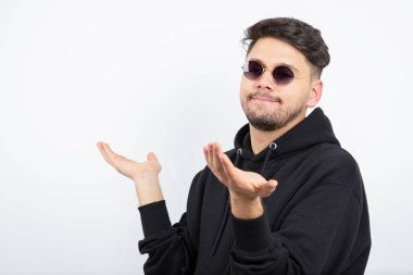 Gözlüklü ve poz veren genç yakışıklı bir adamın fotoğrafı. Yüksek kalite fotoğraf