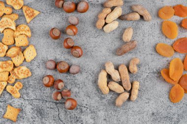 Mermer yüzeyde fındık, kraker ve kurutulmuş kayısı yığını. Yüksek kalite fotoğraf