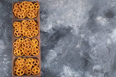 Ahşap tabakta mermer zemin üzerinde tuzlanmış kuru krakerler. Yüksek kalite fotoğraf