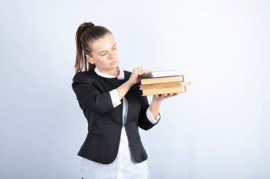 Kitapları tutan ve beyaz arka planda duran genç bir öğrenci resmi. Yüksek kalite fotoğraf