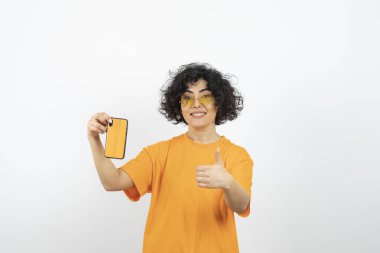 Akıllı telefonlu genç kadın beyaz arka planda poz veriyor 