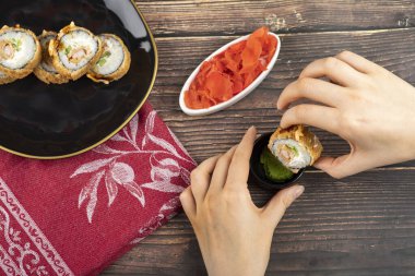 Kadın eli, soya sosuna sıcak suşi koyar. Yüksek kalite fotoğraf