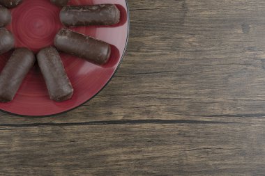 Süt kremalı çikolatalı rulo ile dolu kırmızı bir tabak. Yüksek kalite fotoğraf