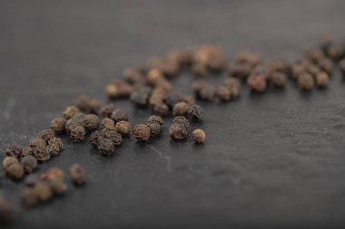 Siyah yüzeye dağılmış organik siyah karabiber yığını. Yüksek kalite fotoğraf