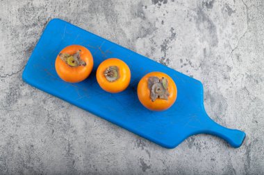 Taş zeminde olgun hurma meyveleriyle dolu mavi tahta. Yüksek kalite fotoğraf