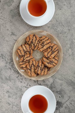 Susamlı kurabiyeler ve mermer yüzeyde iki fincan çay. Yüksek kalite fotoğraf