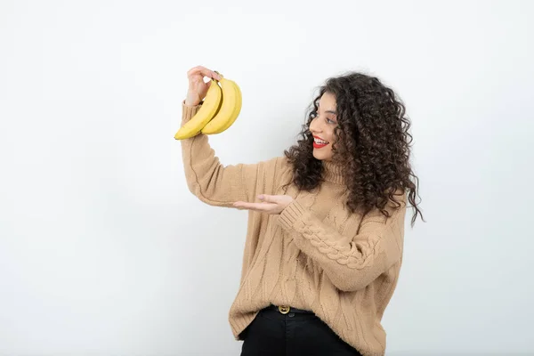 Zdjęcie Kręconej Młodej Kobiety Trzymającej Banany Białym Wysokiej Jakości Zdjęcie — Zdjęcie stockowe