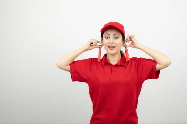 Mujer Atractiva Uniforme Rojo Sosteniendo Expansores Mano Como Pendientes Foto —  Fotos de Stock