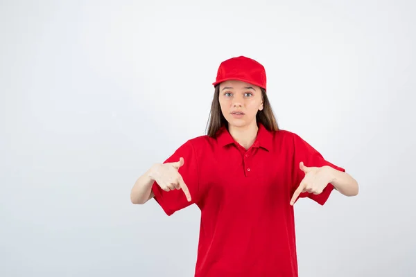 Foto Una Joven Mensajera Uniforme Rojo Señalando Foto Alta Calidad —  Fotos de Stock