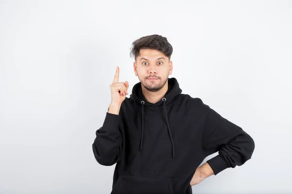 Aantrekkelijke Jongeman Zwart Shirt Die Met Zijn Vinger Omhoog Wijst — Stockfoto