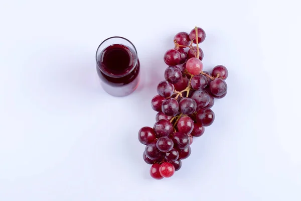 白いテーブルに置かれたジュースのガラスのピッチャーとブドウの束 高品質の写真 — ストック写真