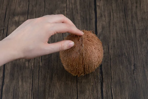 Kvinnlig Hand Håller Mogen Hel Kokosnöt Placerad Ett Träbord Högkvalitativt — Stockfoto